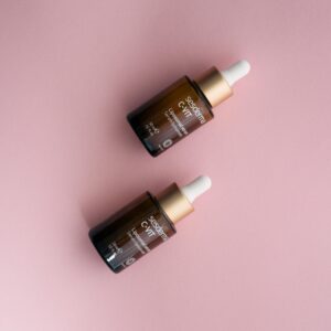 Two Sesderma C-VIT serum dropper bottles on a pastel pink surface.
